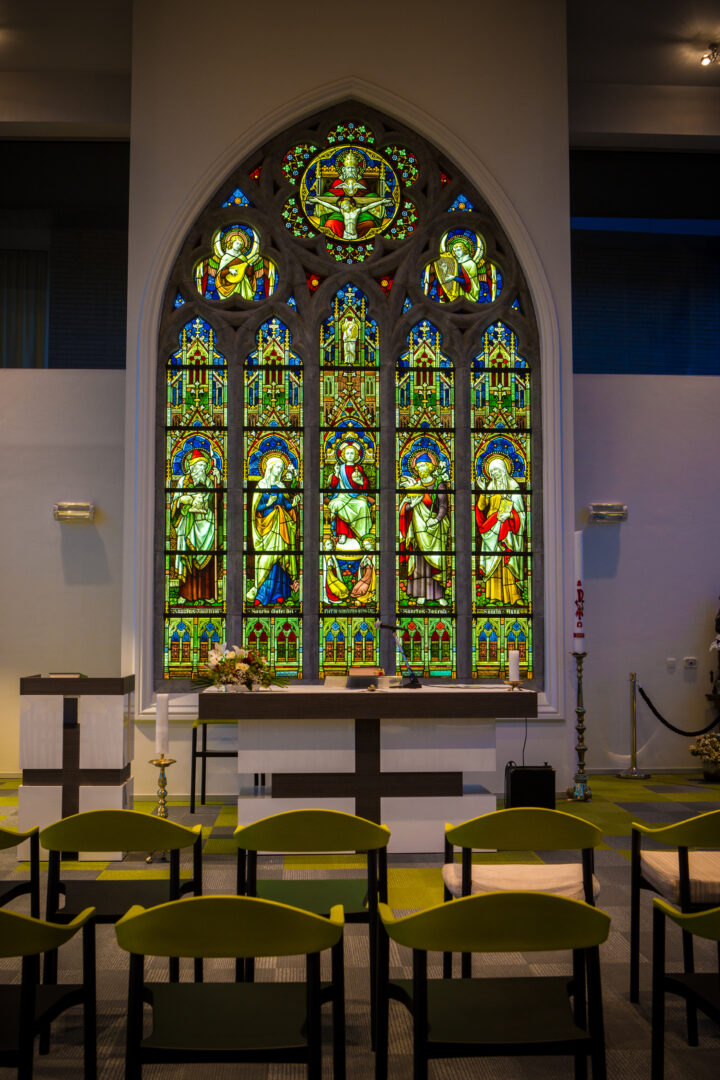 Monumentaal brandglasraam uit kapel Zusters Groene Briel (Gent), geïntegreerd in kapel WZC Westervier (Brugge) als tussenwand, verlicht met LED-sheets – © Wove